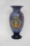 A Royal Doulton vase the mottled blue ground with shaped panels containing tube lined floral sprays