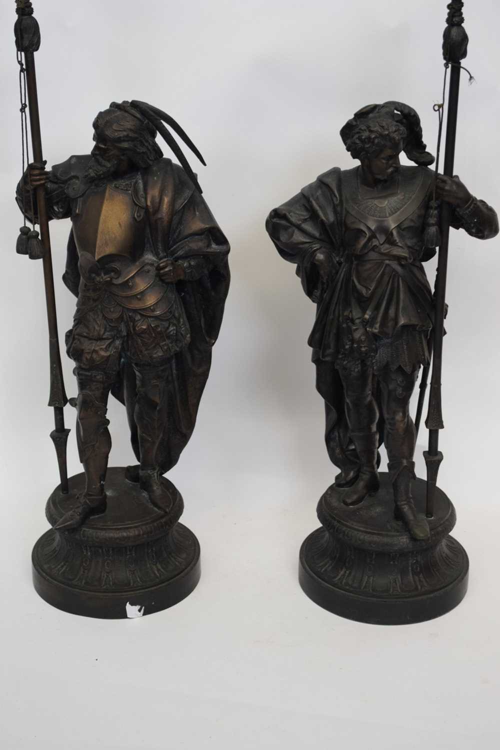 Two large spelter figures of European warriors, both holding spears, mounted on circular bases