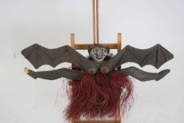 Tribal/ethnographica interest - Papua New Guinea painted wooden bat wall hanging with fibre skirt,