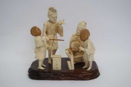 Okimono of a Japanese family with two children playing games, Meiji period, the figures mounted on