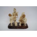 Okimono of a Japanese family with two children playing games, Meiji period, the figures mounted on