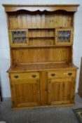 MODERN PINE DRESSER, THE TOP SECTION WITH SMALL LEAD GLAZED DOORS OVER A BASE, WITH TWO DOORS AND