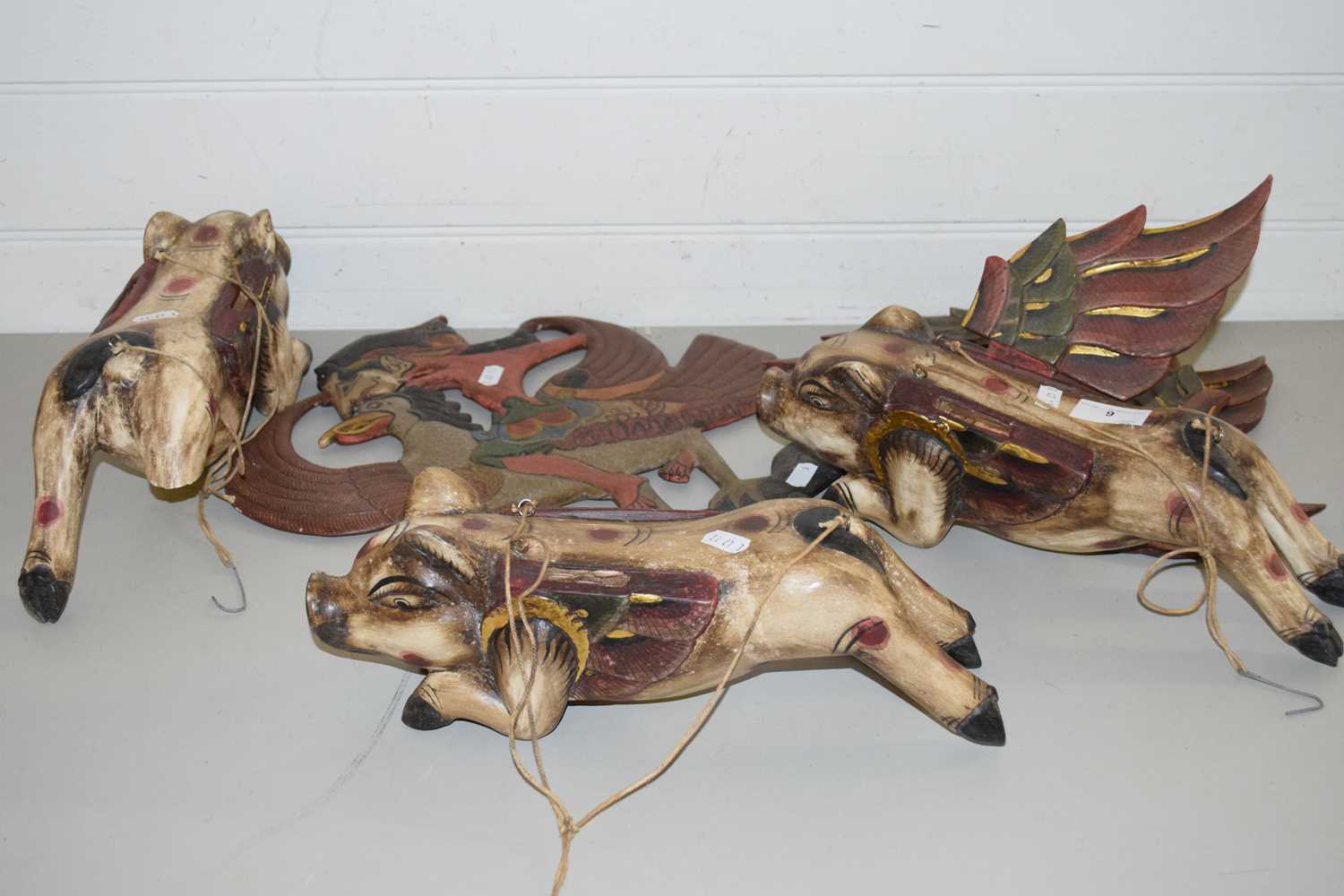 THREE HANGING INDONESIAN WOODEN FLYING PIGS PLUS A FURTHER CUT OUT SHADOW PUPPET