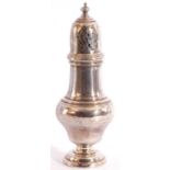 George V silver caster of baluster form, the pierced pull off lid with urn finial, raised on a