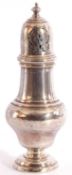 George V silver caster of baluster form, the pierced pull off lid with urn finial, raised on a