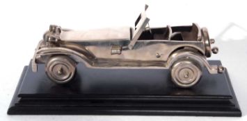 Cast metal model of a open topped vintage sports car set on an ebonised plinth base, the base 35cm
