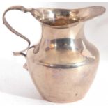 Victorian silver small cream jug, the plain body with wavy rim and border, and a shaped handle,