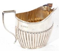 Edwardian silver cream jug of oval form, half fluted decoration having a reeded handle and applied