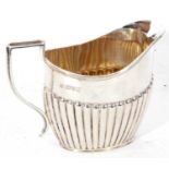 Edwardian silver cream jug of oval form, half fluted decoration having a reeded handle and applied