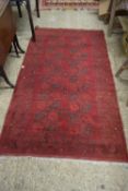 20TH CENTURY RED WOOL BOKHARA TYPE FLOOR RUG WITH LARGE CENTRAL LOZENGES, 210CM LONG