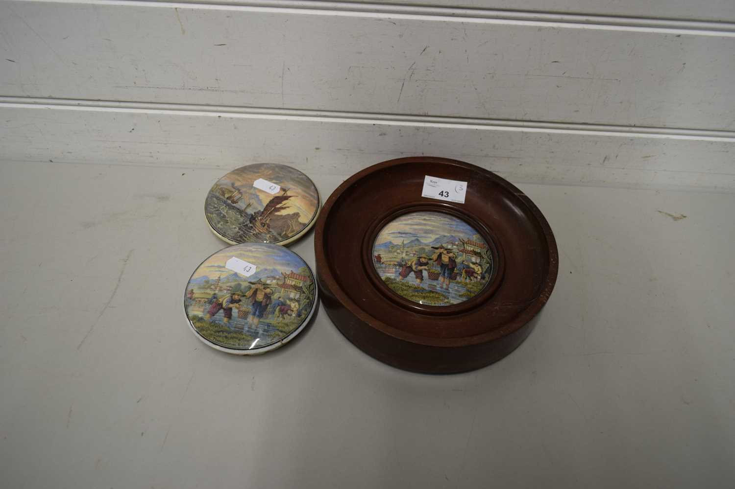 THREE VARIOUS PRATT WARE POT LIDS, ONE SET IN A WOODEN FRAME