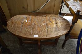 20TH CENTURY WEST AFRICAN HARDWOOD COFFEE TABLE WITH OVAL TOP CARVED WITH FIGURES, 73CM WIDE
