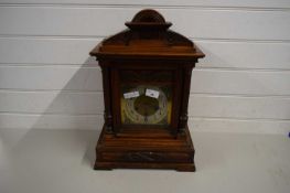 WALL CLOCK IN ORNATE WOODEN FRAME WITH COLUMNS FLANKING SILVERED DIAL