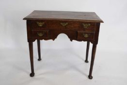 George III oak lowboy, fitted with one long and two short drawers, brass handles, raised on tapering