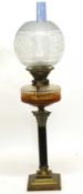 Late 19th century oil lamp with Corinthian column and amber glass reservoir with white engraved