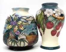 Two Moorcroft vases, one with tube lined design of cherries, the other in the Islay design (2)
