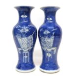 Two 19th century Chinese porcelain vases, the blue ground decorated with precious objects, 25cm high