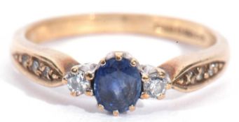 9ct gold sapphire and diamond three stone ring, the oval shaped small faceted sapphire flanked by