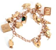 9ct gold curb link chain suspending various 9ct gold charms to include a swan, football, lantern,