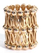An expanding ring/bracelet, drum shaped with bead and oval links that become round when fully