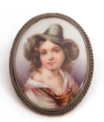 Vintage hand painted porcelain brooch of oval form depicting a young lady in a green hat, framed