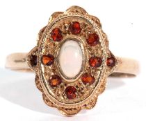 9ct gold opal and red stone ring, the cabochon oval shaped opal bezel set and raised within a red