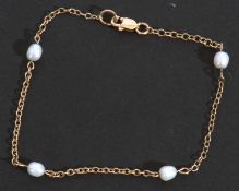 Yellow metal and seed pearl bracelet, the small oval link chain highlighted with four drum shaped