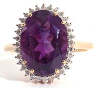 Modern 18ct gold amethyst and diamond ring, the oval faceted amethyst set within a small diamond