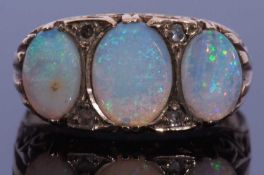 9ct gold opal and diamond ring, a design featuring three graduated oval shaped opals, highlighted