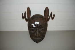 AN UNUSUAL IRON FULL HEAD HELMET WITH PIERCED FACE AND SPIRAL HORNS