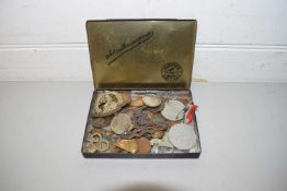 SMALL TIN CONTAINING MILITARY CAP BADGES AND VARIOUS WORLD COINAGE