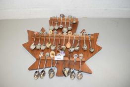 COLLECTION VARIOUS CRESTED COLLECTORS SPOONS ON A MAPLE LEAF SHAPED HOLDER