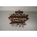 COLLECTION OF CRESTED COLLECTORS SPOONS ON A MAPLE LEAF SHAPED HOLDER