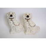 Pair of Staffordshire pottery spaniels with gilt finish detail, 27cm high