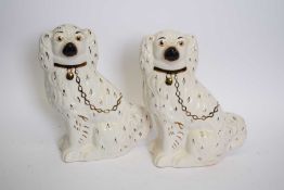 Pair of Staffordshire pottery spaniels with gilt finish detail, 27cm high