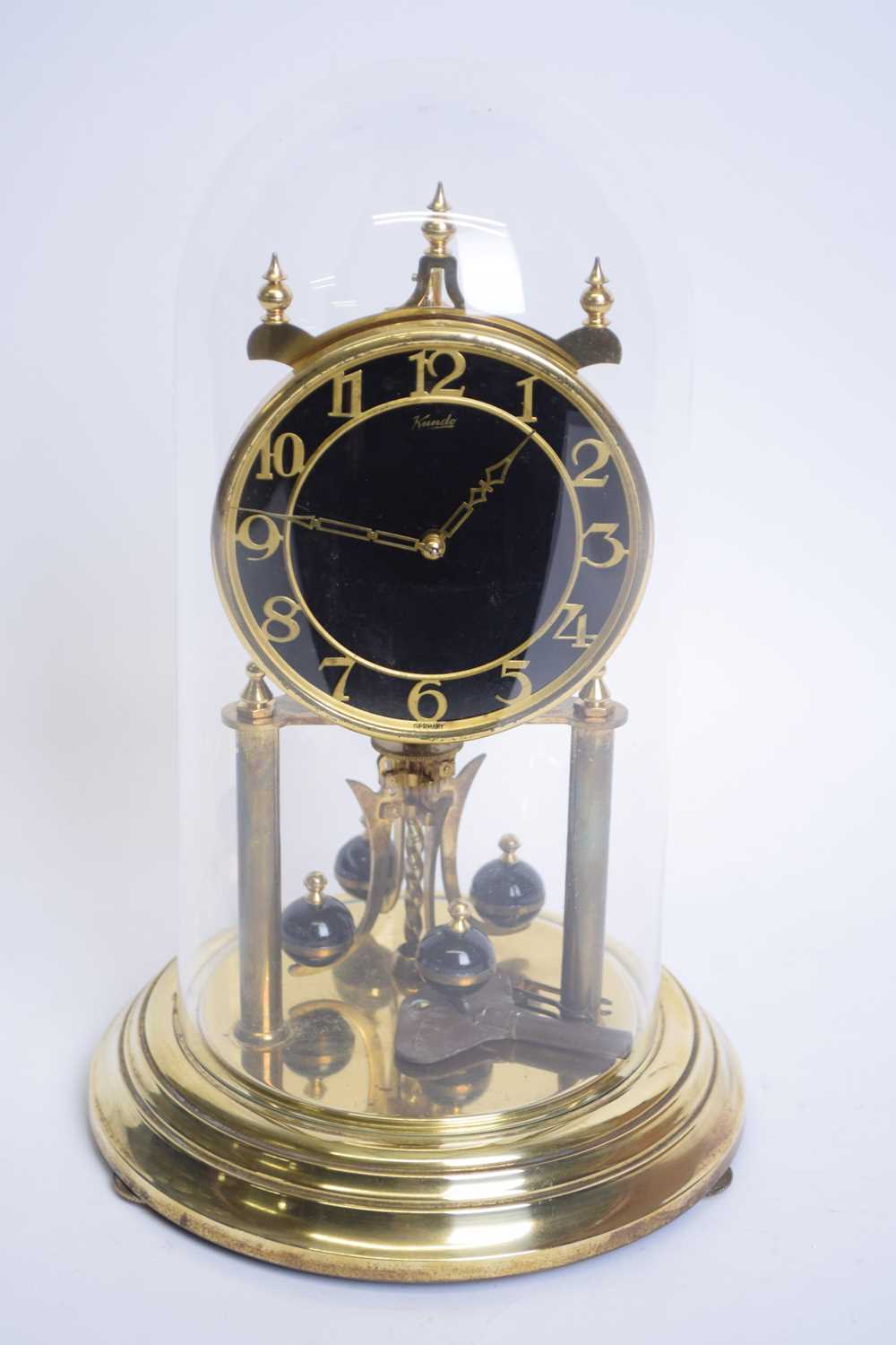 Kundo brass torsion or anniversary clock set under a glass dome, 30cm high