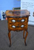 Small French walnut two-drawer bedside cabinet of serpentine form, the drawers with gilt metal and