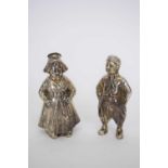 Pair of Continental white metal pepperettes formed as a couple in traditional dress, 7cm high