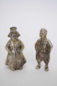 Pair of Continental white metal pepperettes formed as a couple in traditional dress, 7cm high