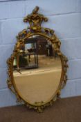 20th century giltwood wall mirror of Italian manufacture with oval plate surrounded by a frame