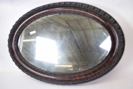 Early 20th century oval wall mirror in dark wood frame, 82cm wide