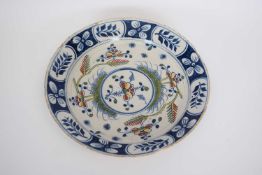 Large 18th century Delft charger, the centre with a floral polychrome design within a blue border,