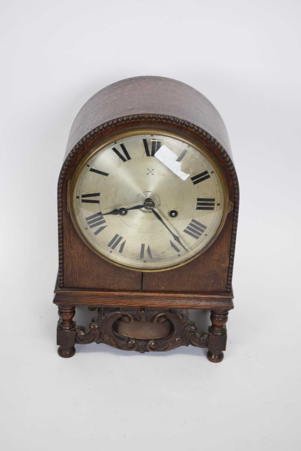 Early 20th century oak cased mantel clock of domed form raised on small turned legs with the unusual