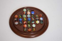 Hardwood solitaire board complete with marbles, the board 18cm diam