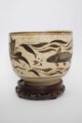 Interesting Asian pottery bowl decorated with fish, possibly Korean, 19cm diam, on wooden stand