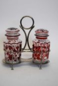 Silver plated cruet containing a pair of clear and red vine decorated lidded jars