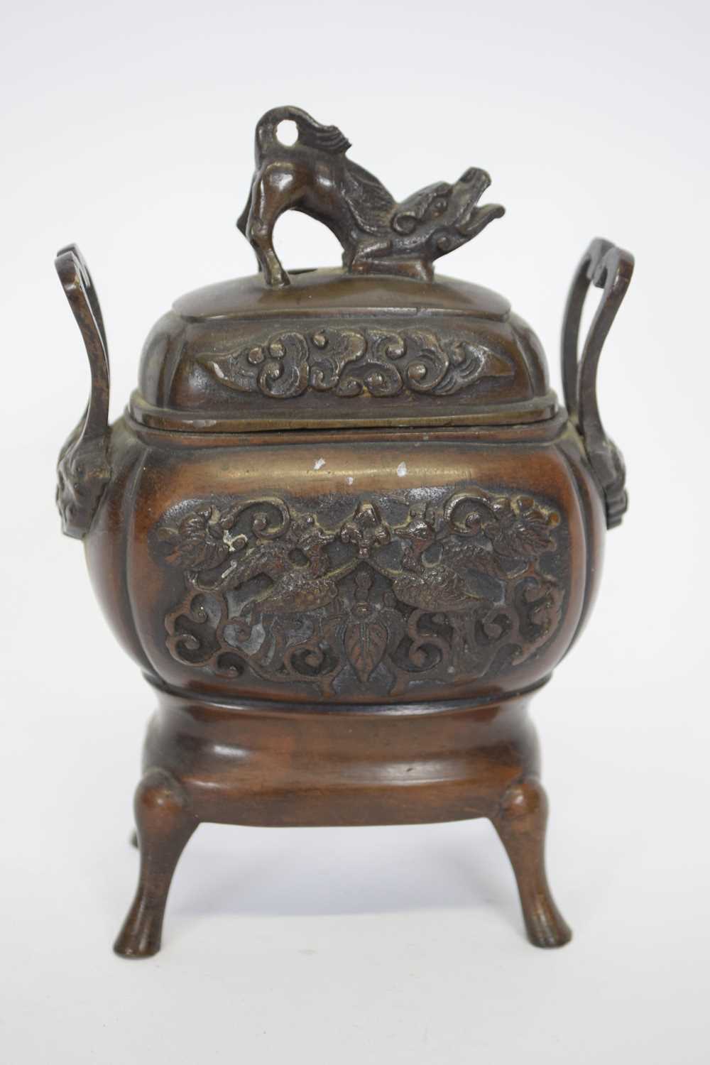 Oriental incense burner and cover raised on four feet, the vase with an impressed design of birds in