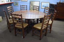 20th century oak oval drop leaf dining table raised on turned legs together with a set of eight rush