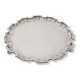 Large George V silver salver of plain shaped circular form having 'Chippendale' edge and raised on