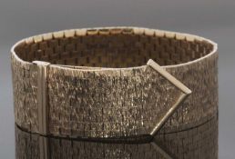9ct gold bracelet of articulated brick link form with bark effect finish and folding buckle